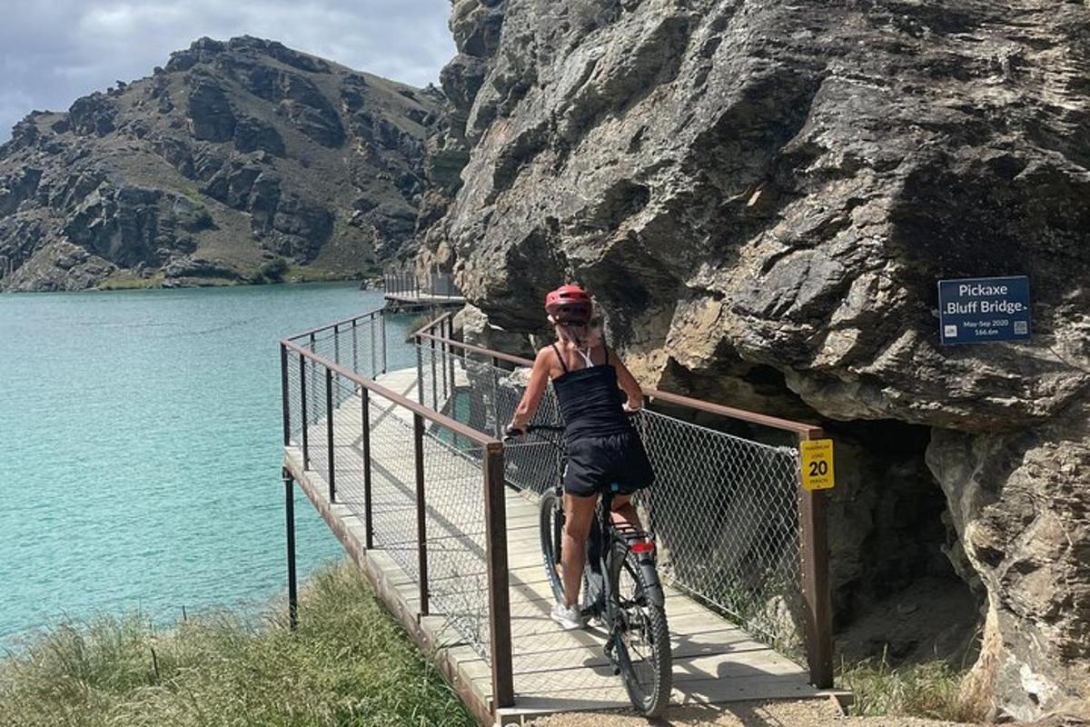 una dona anant en bicicleta per un pont sobre un llac