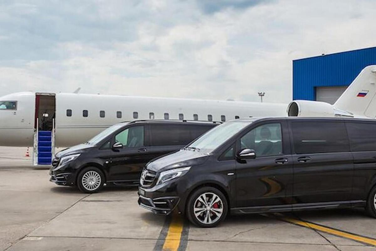 hai chiếc xe tải màu đen đỗ cạnh một chiếc máy bay