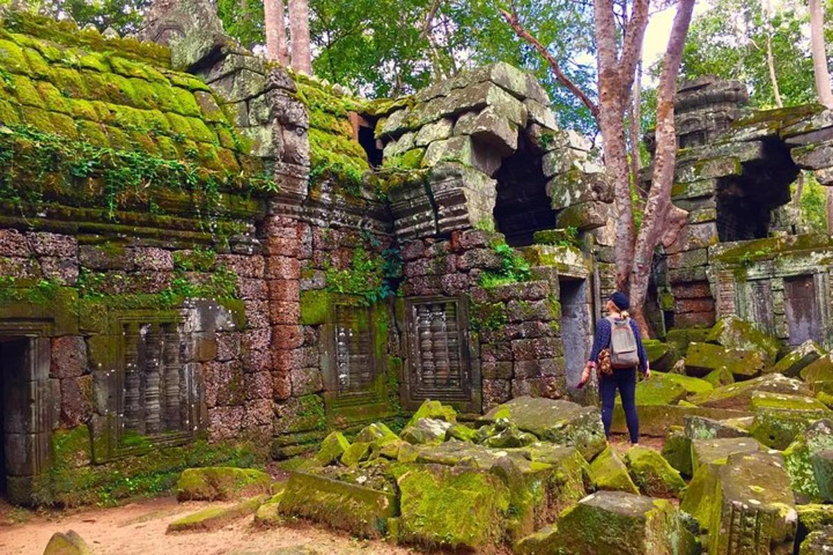 osoba stojící před budovou porostlou mechem
