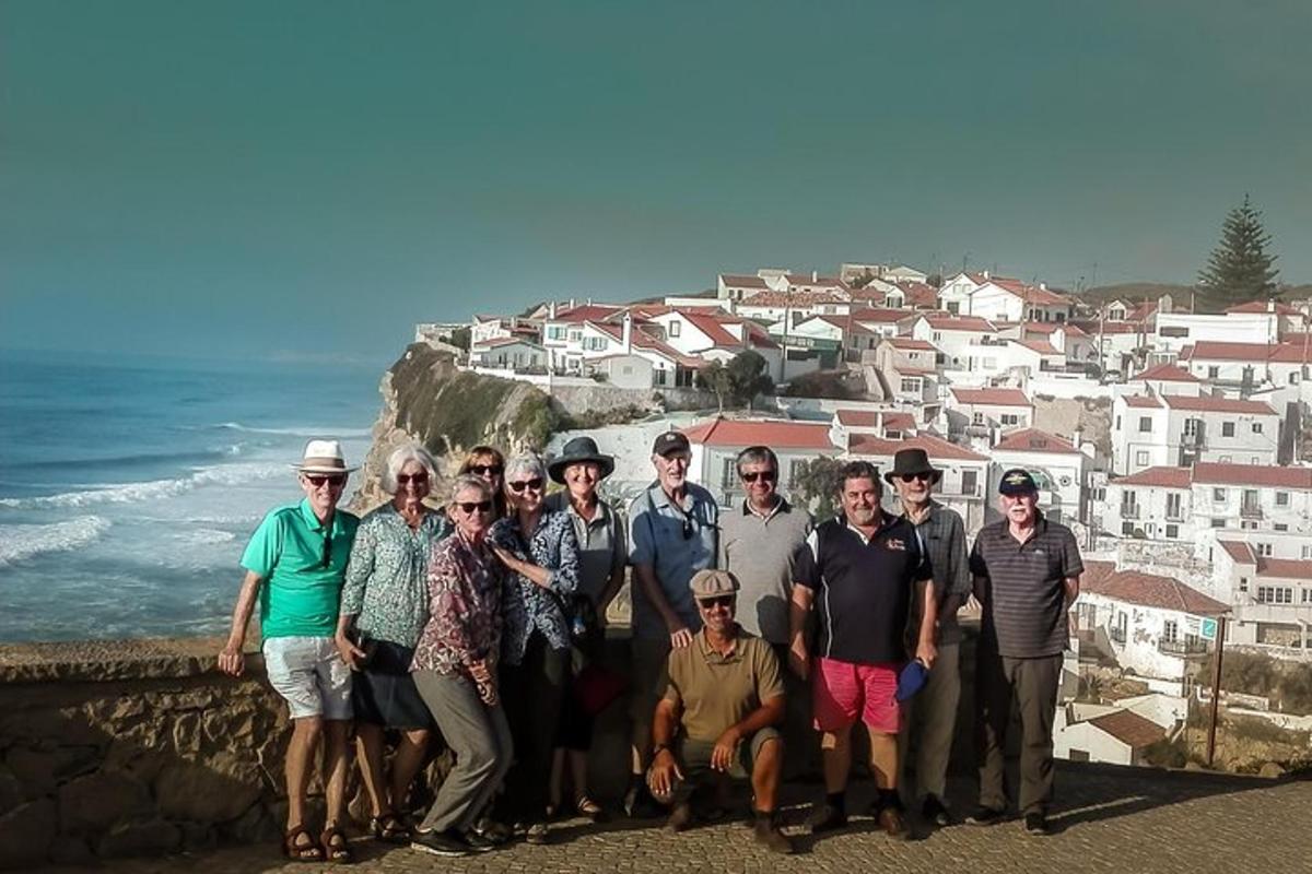 eine Gruppe von Menschen posiert für ein Foto vor dem Meer
