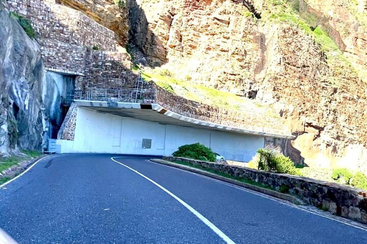 una strada di fronte a una montagna con un tunnel
