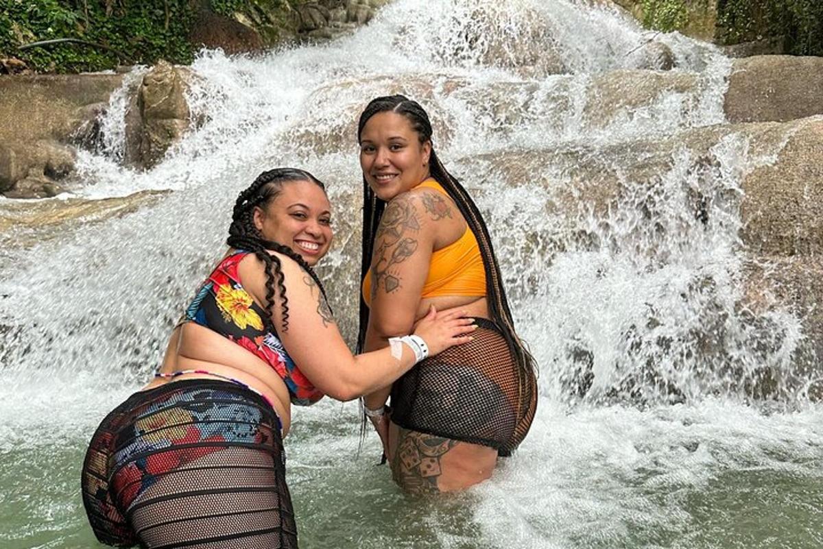 due donne in piedi nell'acqua di una cascata