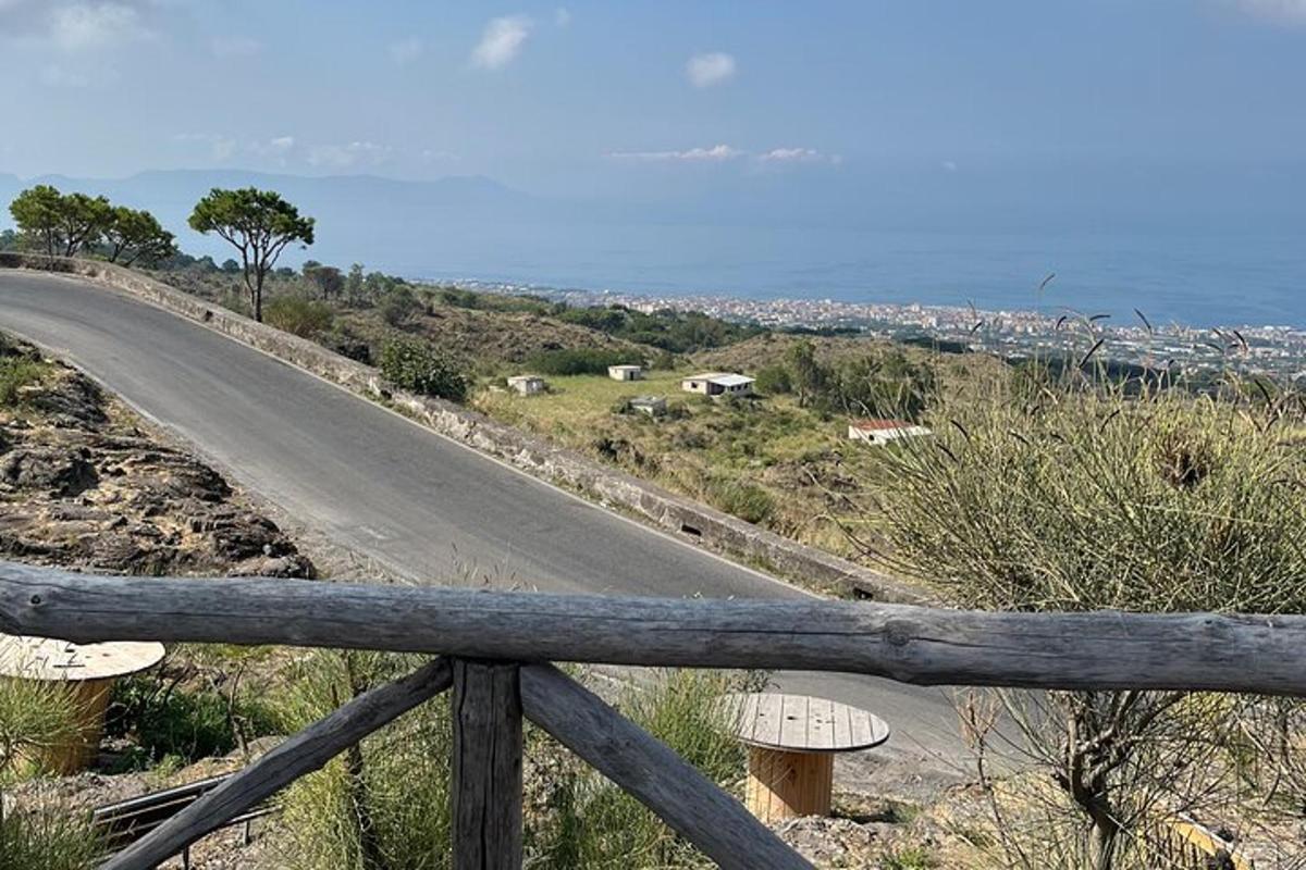 Una carretera vacía en una colina con una valla
