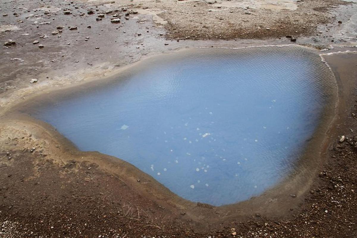 uma poça de água no meio de um campo de terra