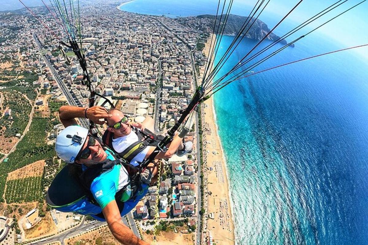 un uomo appeso a un paracadute sopra l'oceano