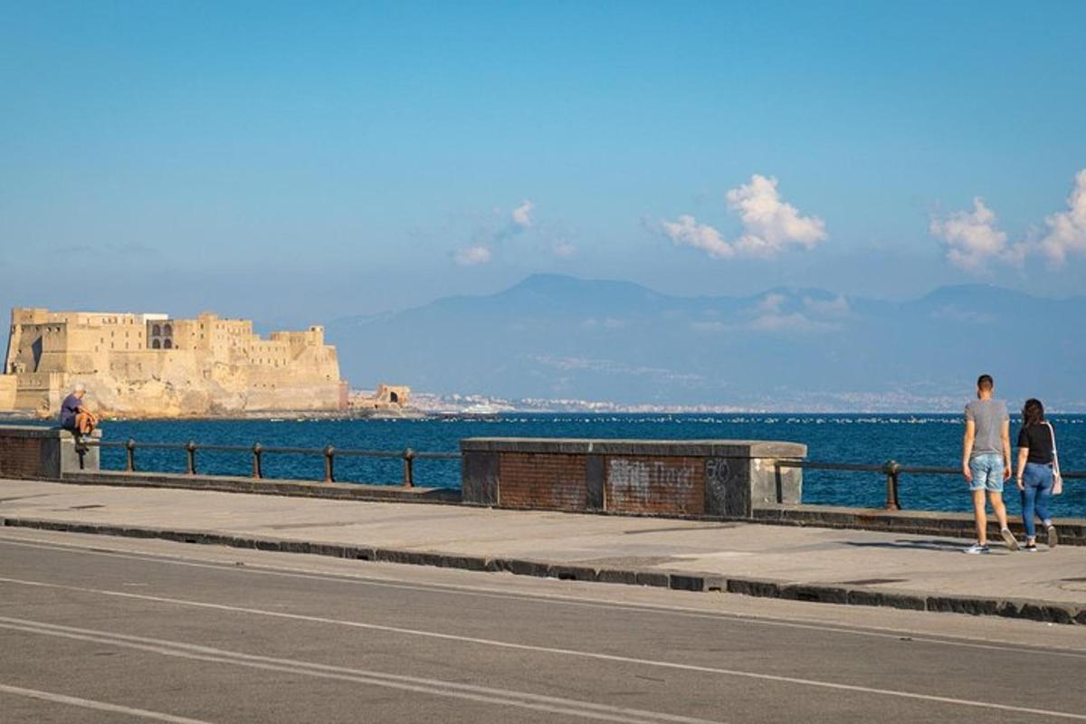 due persone che camminano su un marciapiede vicino all'oceano