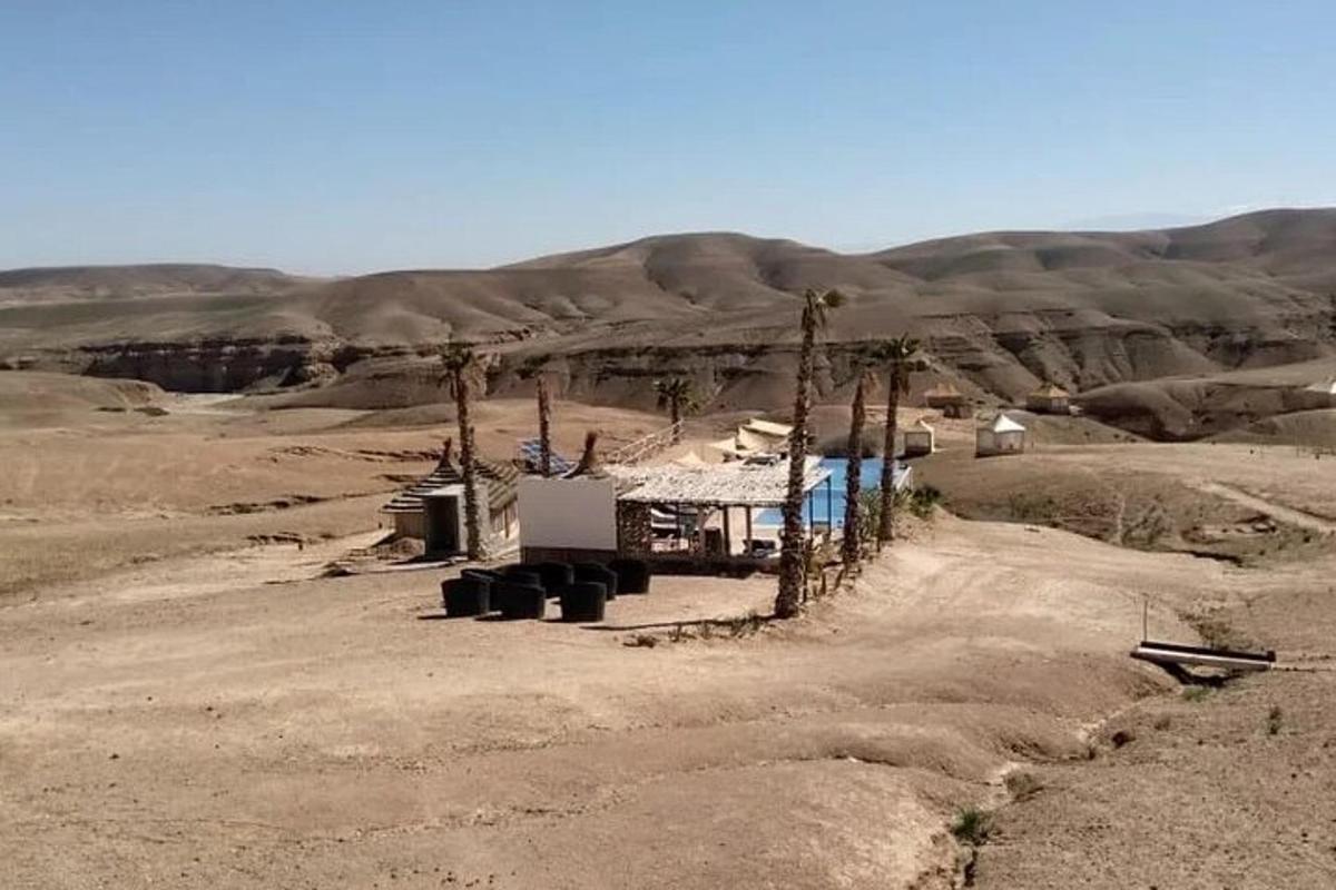 un edificio in mezzo a un deserto con una montagna