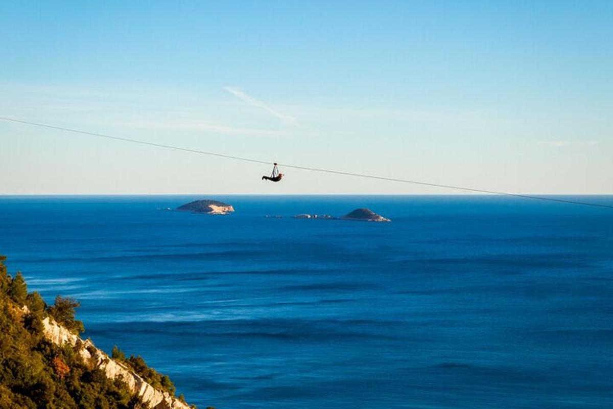 un helicòpter volant sobre l'oceà a prop d'un penya-segat