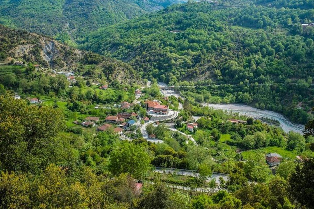 an aerial view of a village in a valley with a river