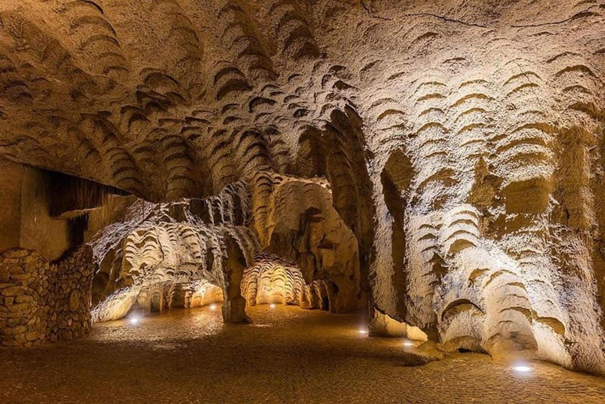 una grotta con un soffitto di roccia con luci al suo interno