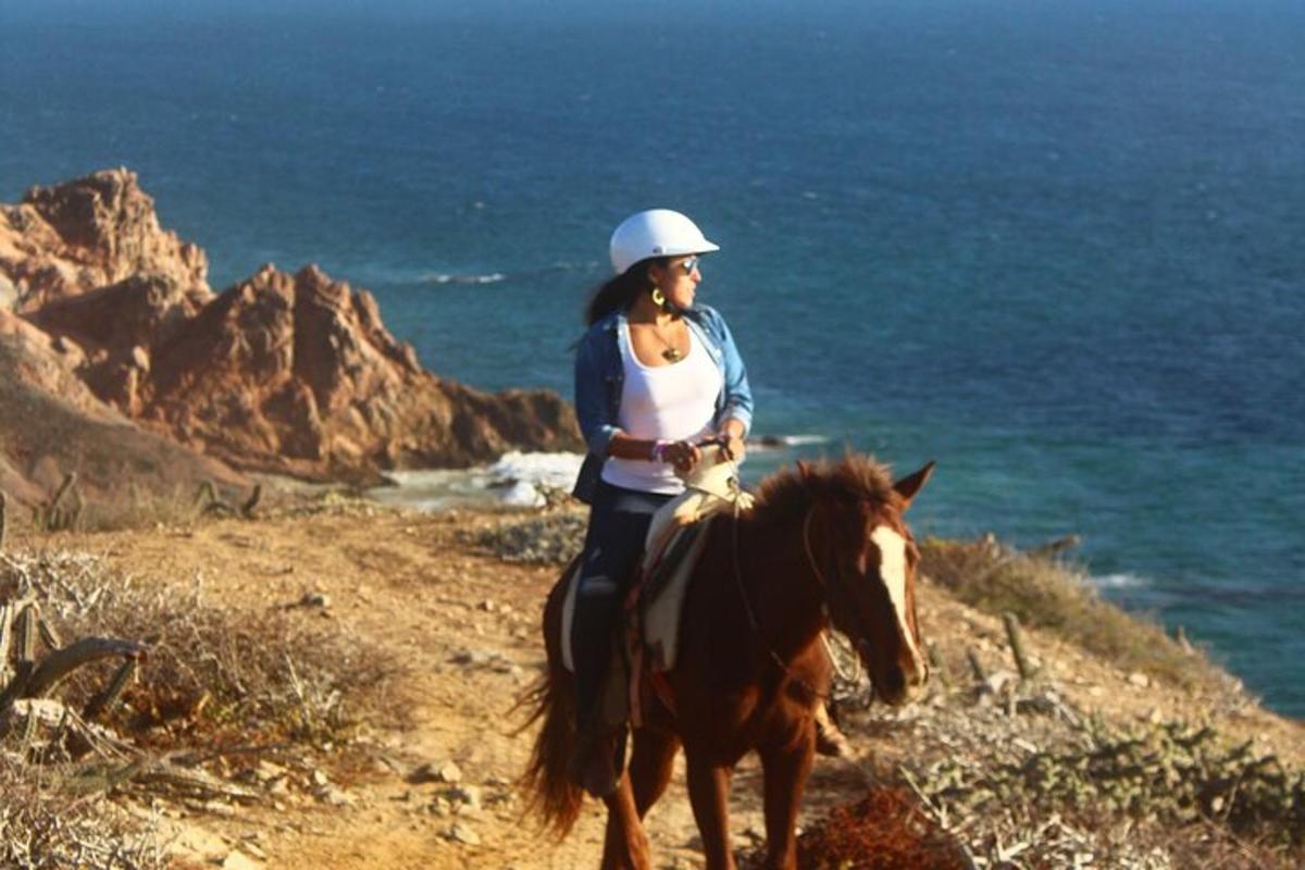 una donna a cavallo sulla spiaggia