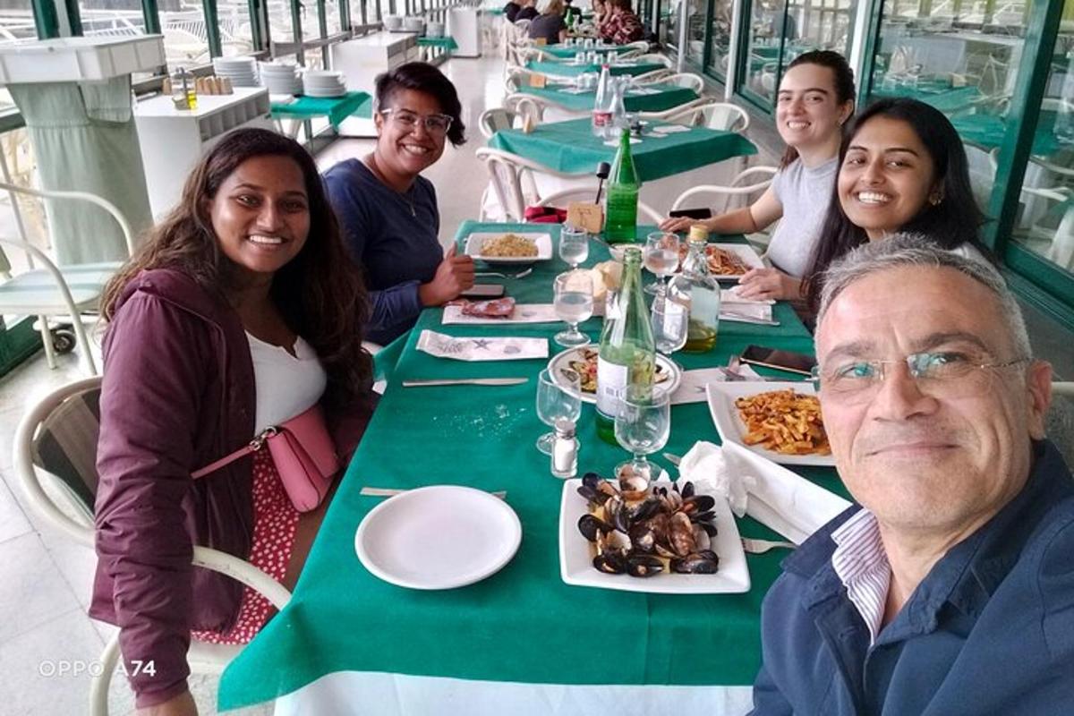 un gruppo di persone sedute a un tavolo che mangiano cibo