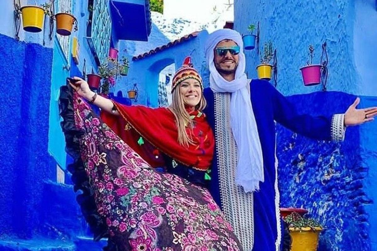 seorang lelaki dan seorang wanita bergambar di hadapan bangunan biru