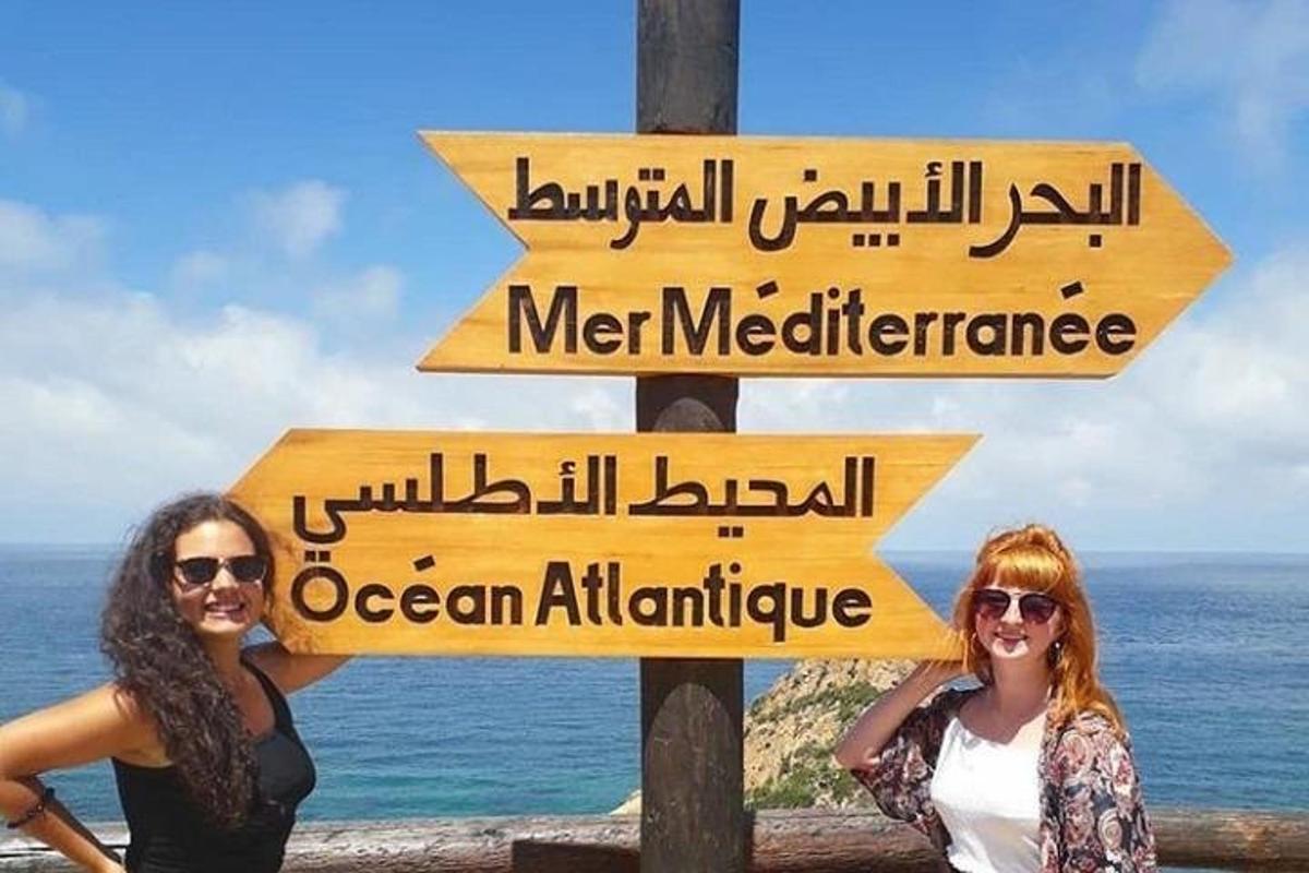 duas mulheres em pé ao lado de uma placa de rua com placas