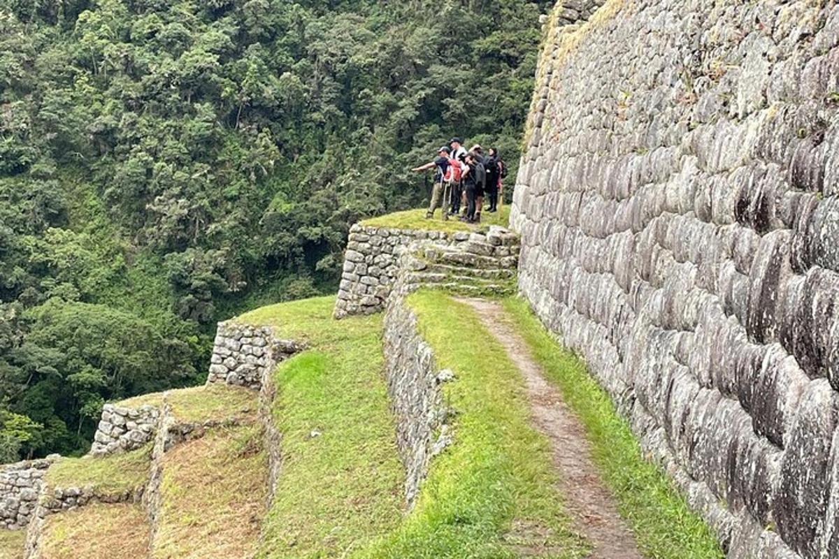 Un grupo de personas de pie encima de un muro de piedra.