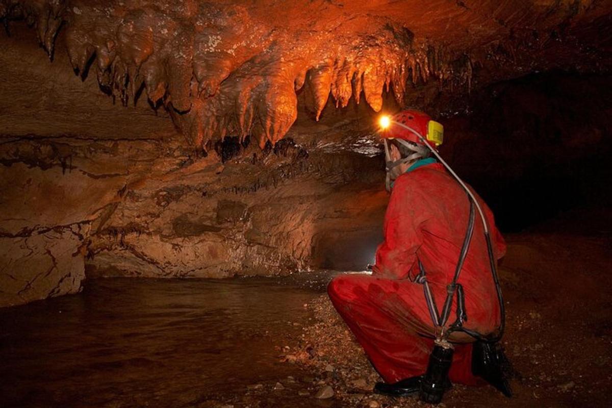 Ein Mann sitzt in einer Höhle mit Eisformationen