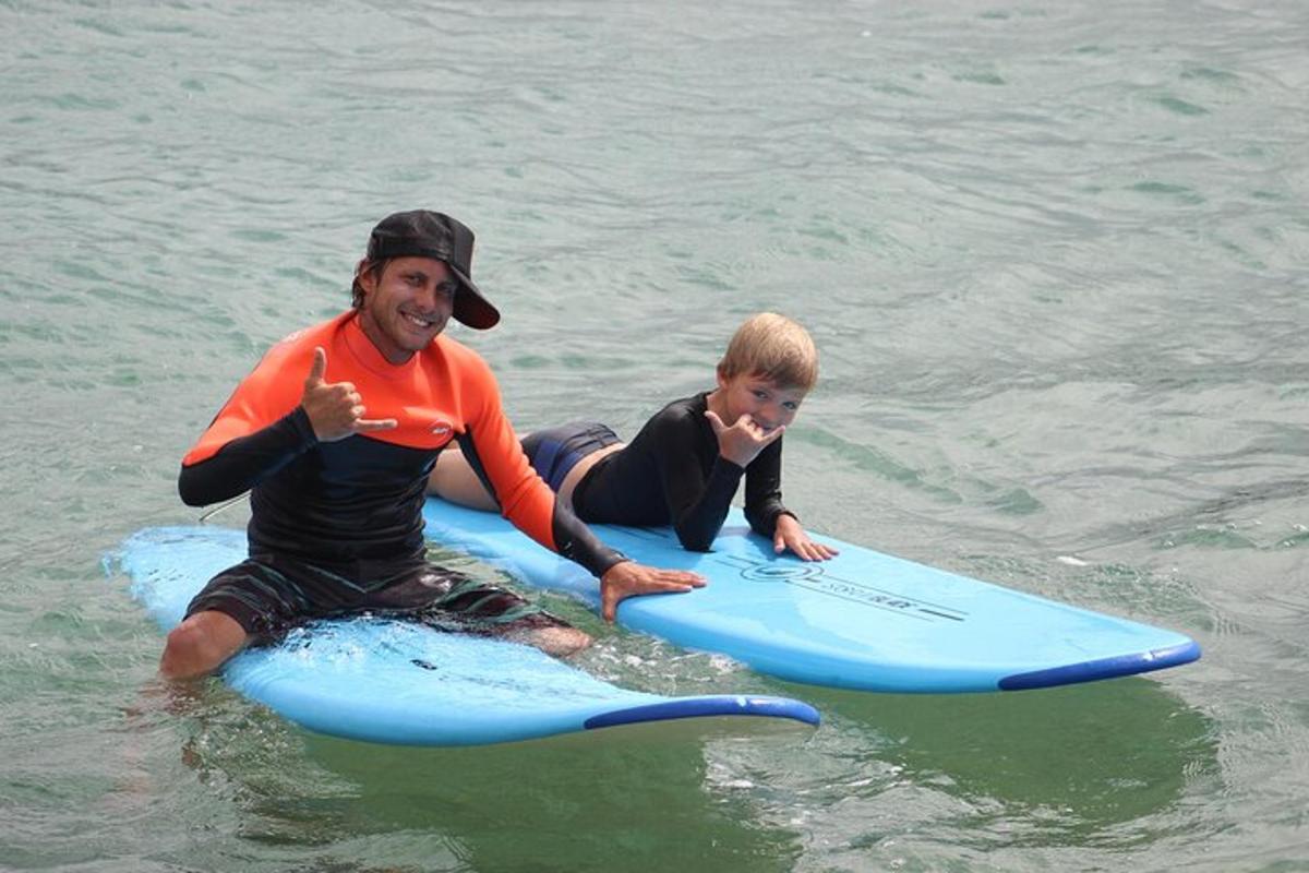 a man and a child on surfboards in the water