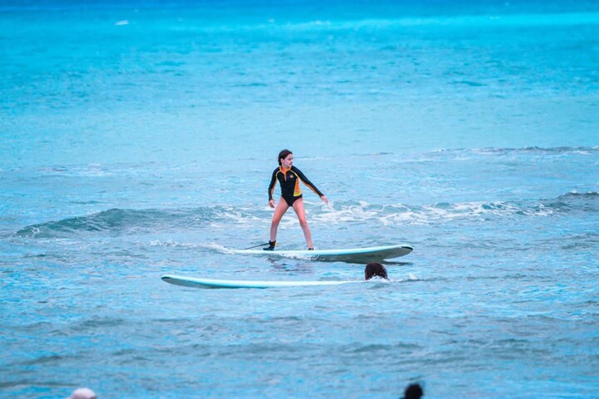 a woman standing on a surfboard in the ocean