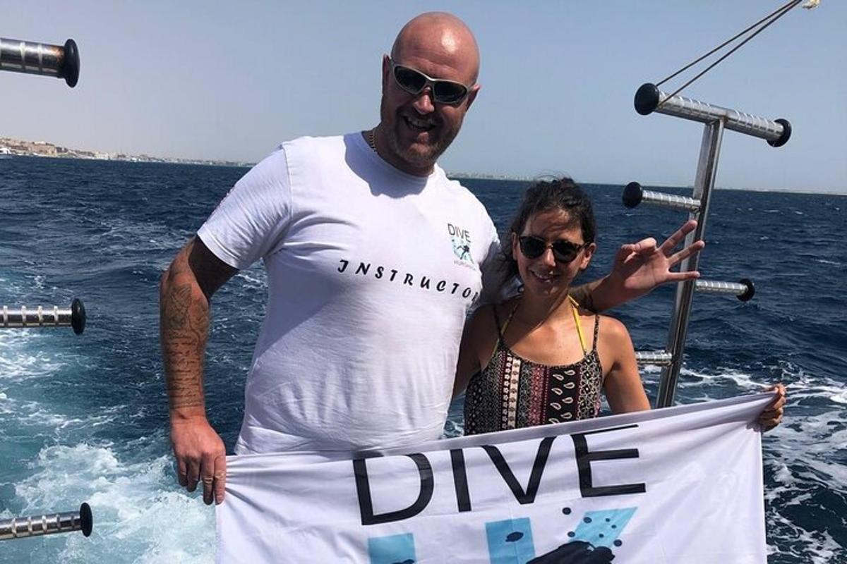 Un hombre y una mujer sosteniendo un cartel en el agua.