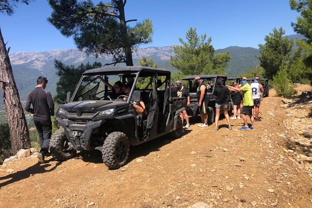 Un grupo de personas de pie alrededor de un jeep en un camino de tierra.