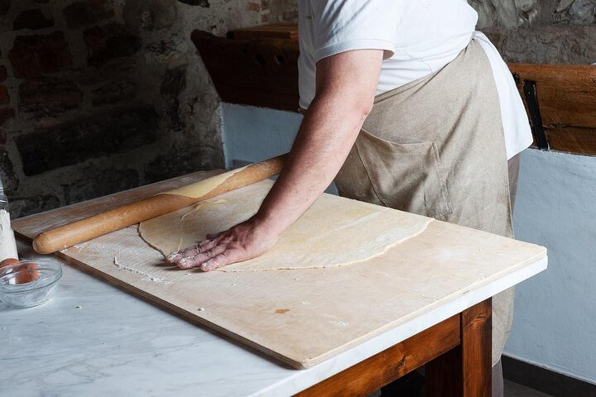 un uomo sta impastando la pasta su un tagliere