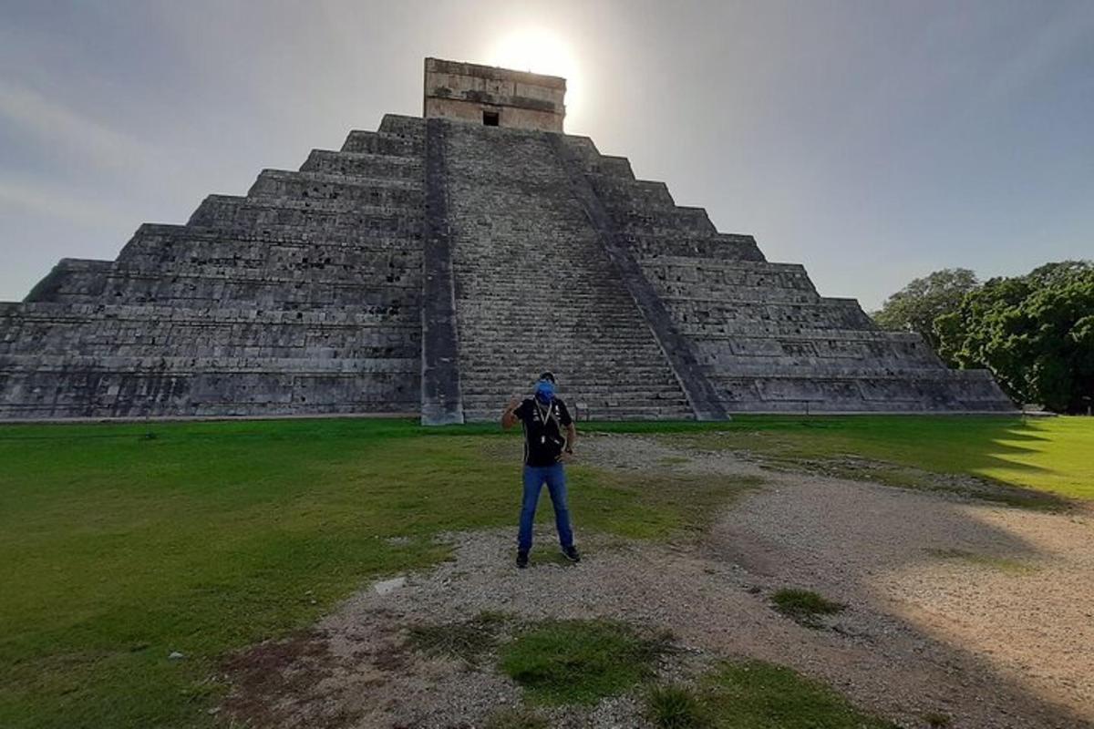 osoba stojící před pyramidou