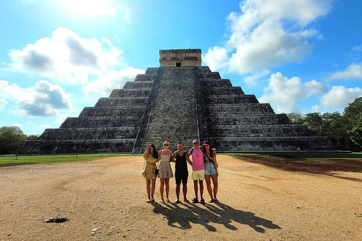 skupina lidí stojící před pyramidou