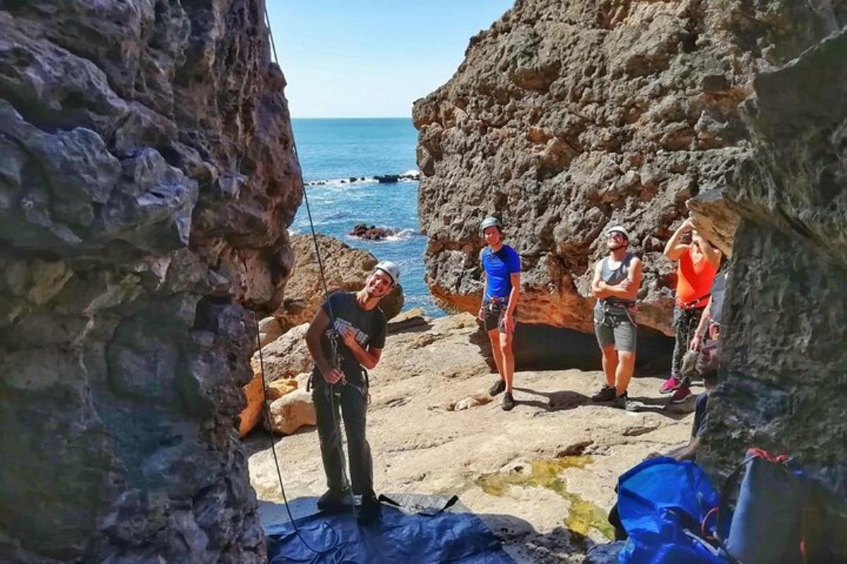 skupina lidí stojících na skalách u oceánu