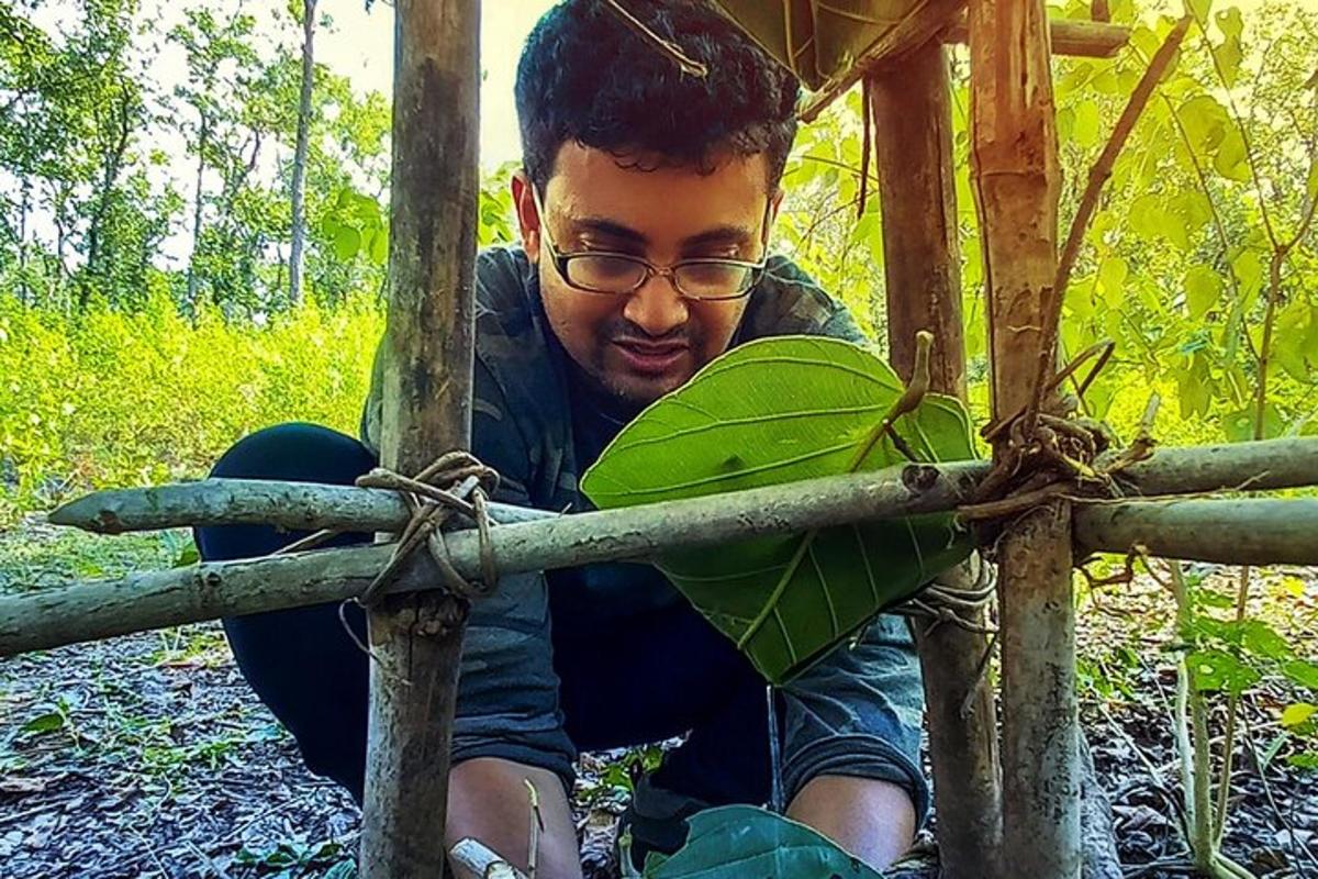 seorang lelaki muda memegang pokok hijau
