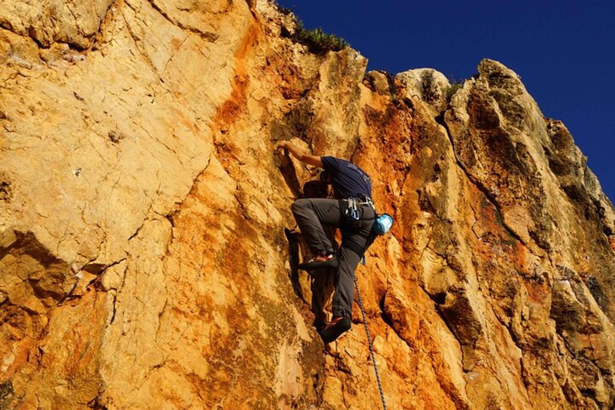 un uomo che si arrampica sul fianco di una montagna