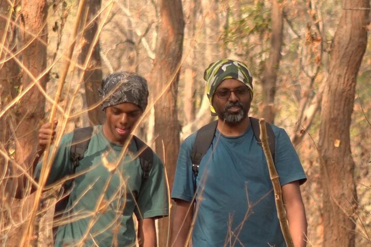 dua lelaki berjalan menyusuri denai di dalam hutan