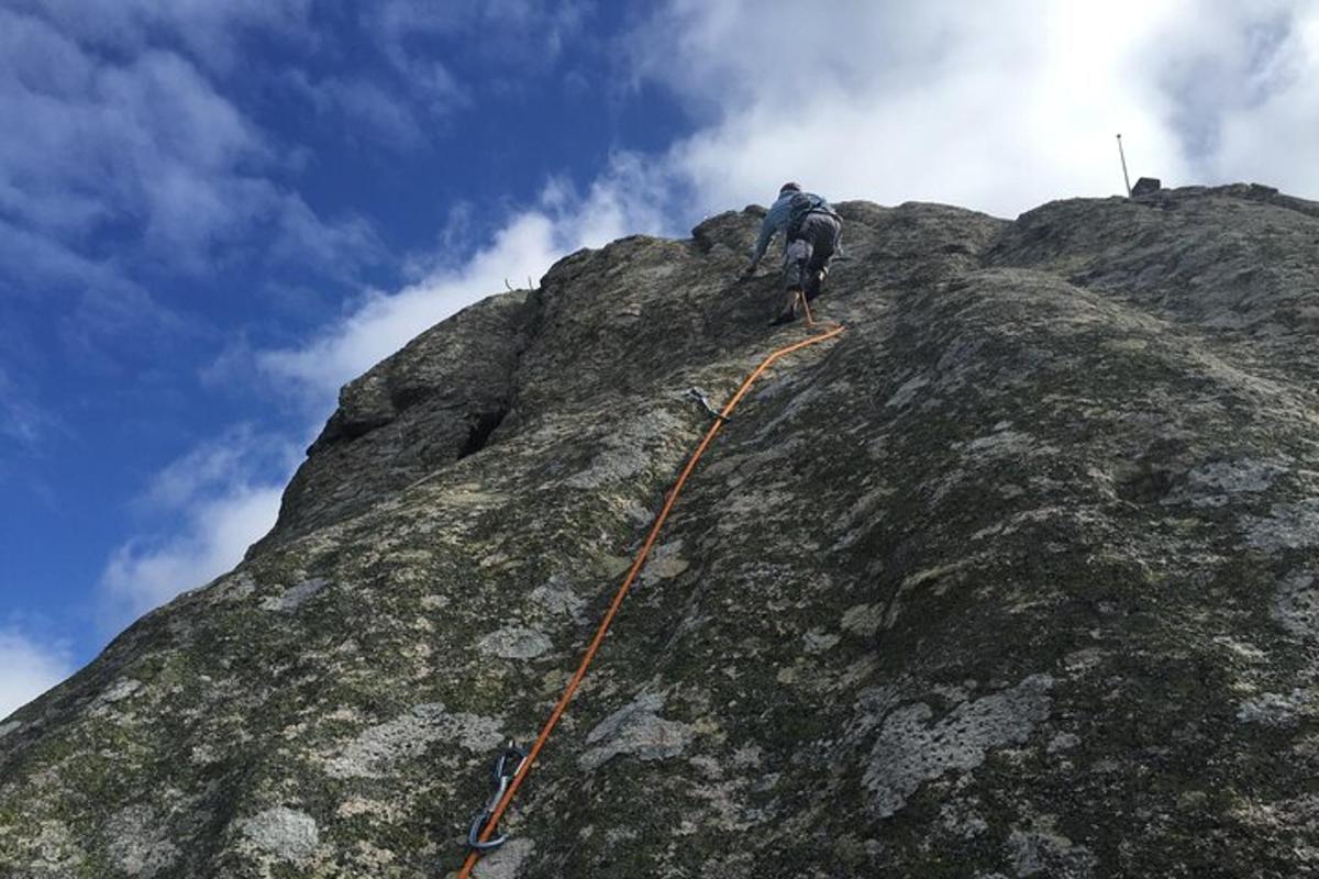 um homem parado na encosta de uma montanha