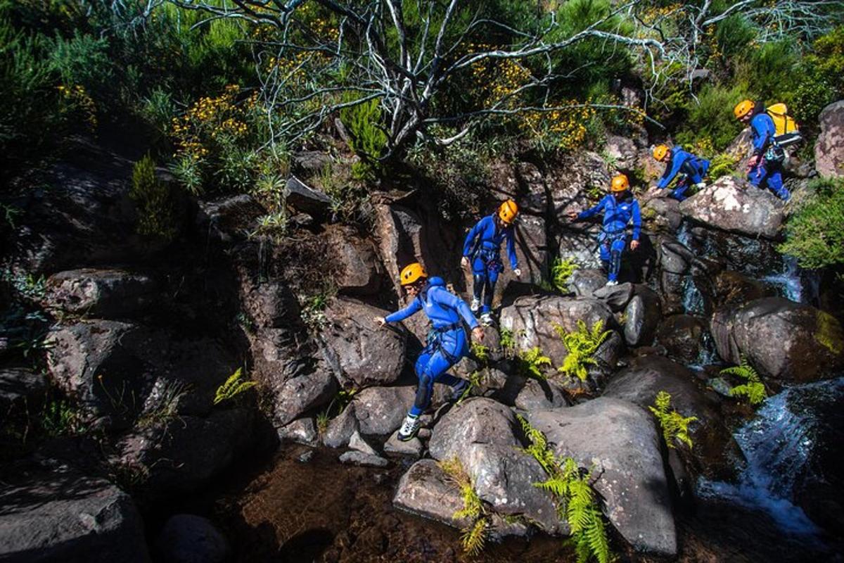 sekumpulan orang berjalan di atas batu berhampiran air terjun