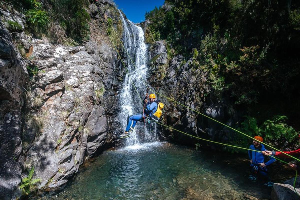 dua orang di atas tali di hadapan air terjun