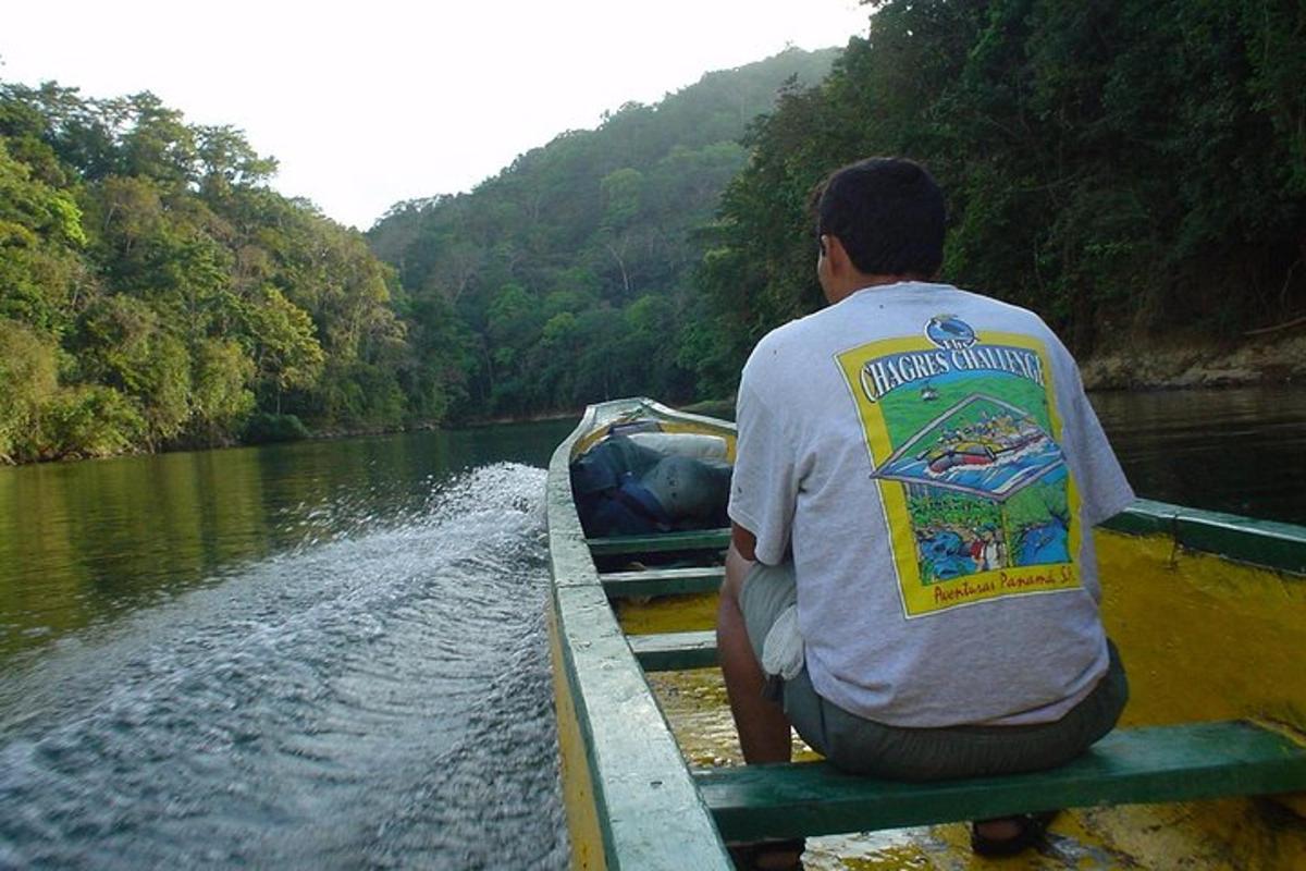 un hombre sentado en un bote en un río