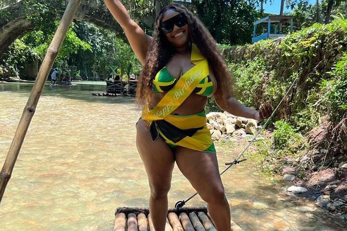 uma mulher de biquíni em pé em uma jangada na água