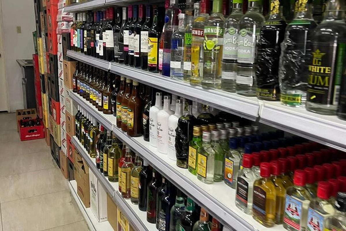 un raft de magazin plin cu o mulțime de sticle de alcool