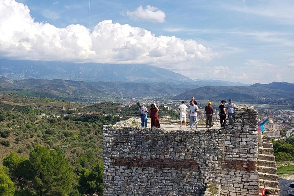 μια ομάδα ανθρώπων που στέκονται πάνω σε έναν πέτρινο τοίχο