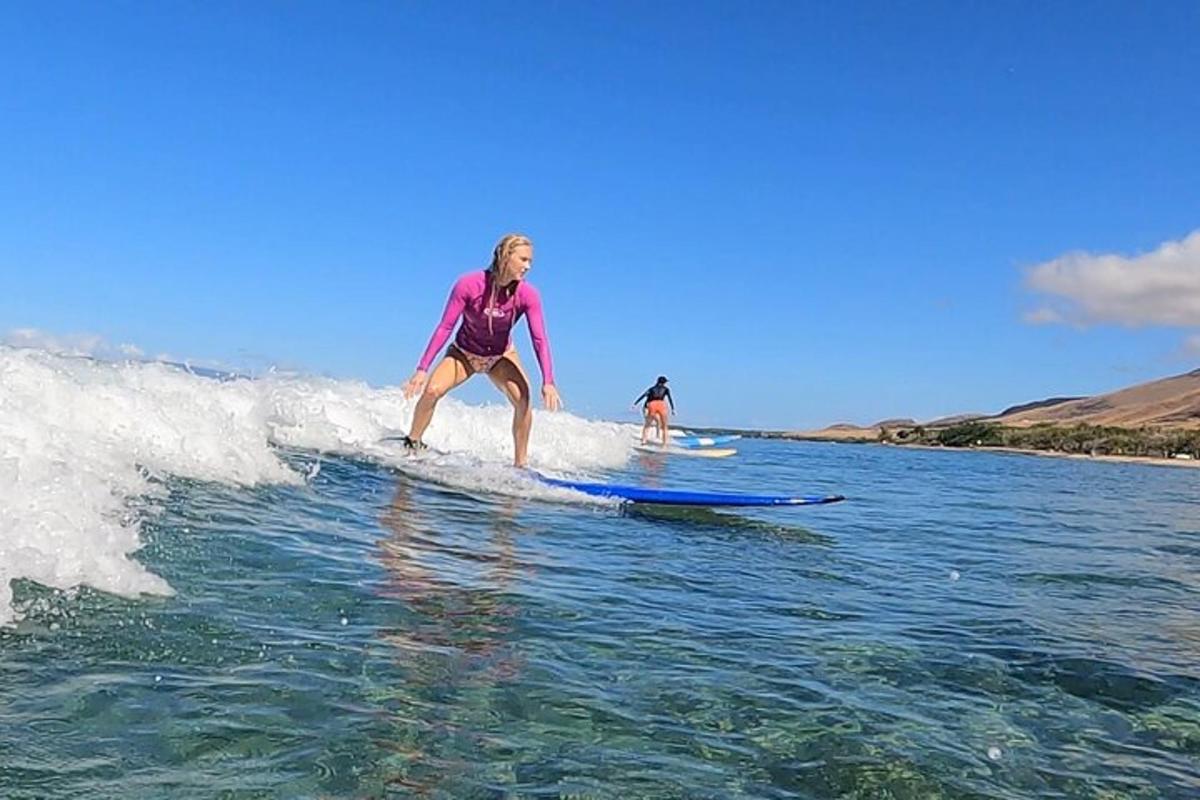 жінка катається на хвилі на дошці для серфінгу у воді