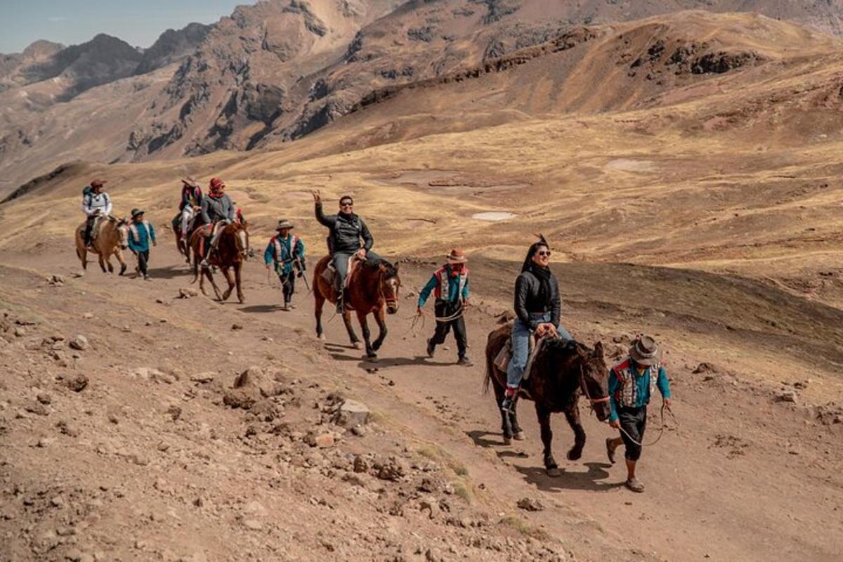 Un grupo de personas montando a caballo por un camino de tierra.