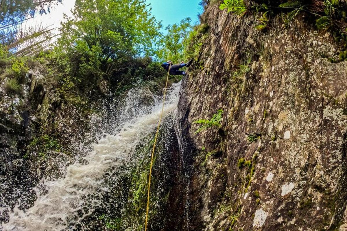 a person rappelling off of a waterfall