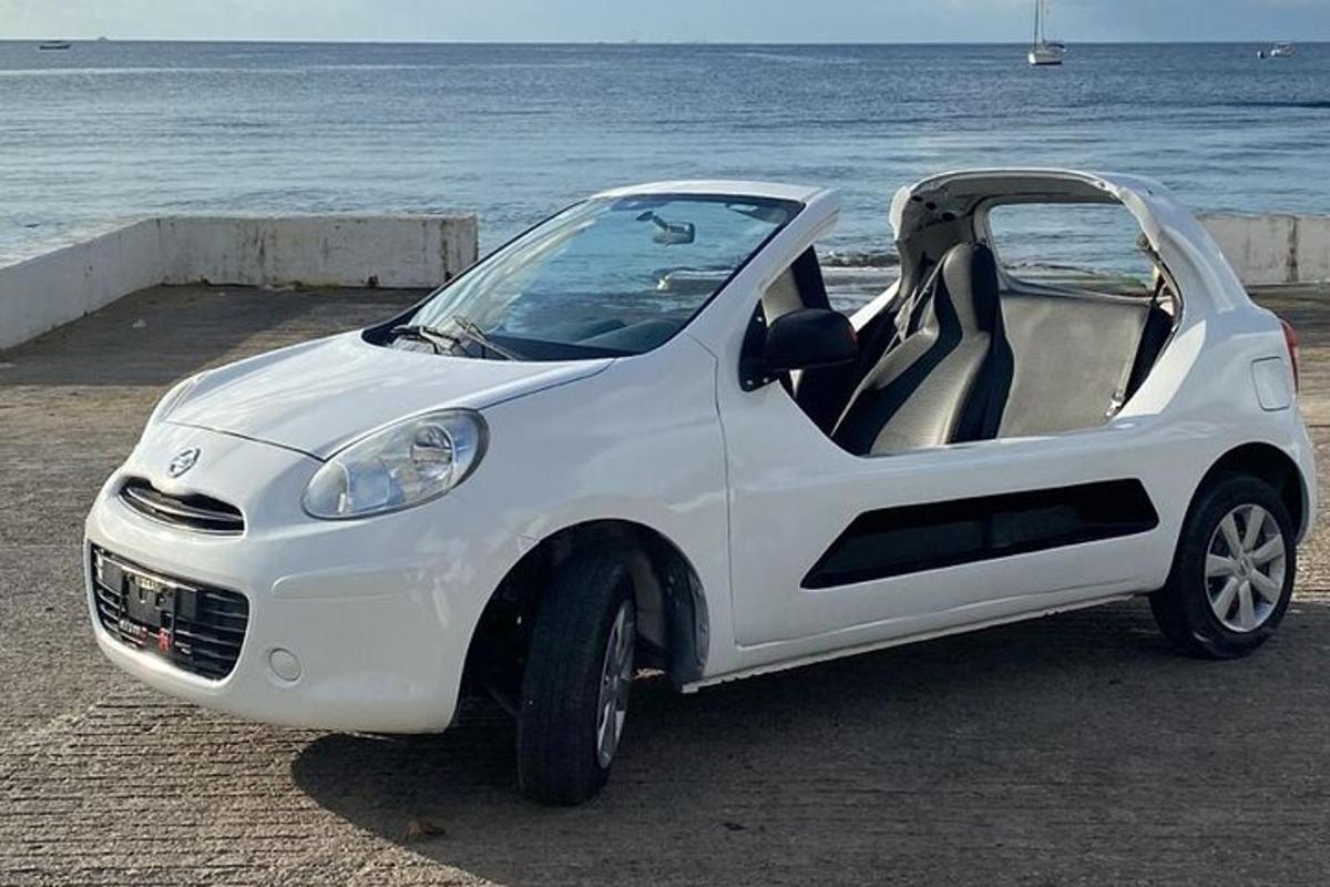 ein weißes Auto, das neben dem Meer geparkt ist