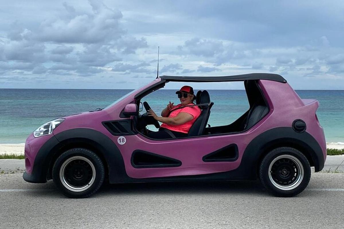 ein Mann, der in einem rosa Auto mit offenen Türen sitzt