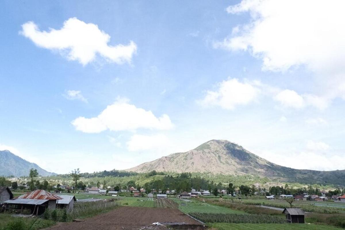uma vista de uma montanha com uma cidade e um campo