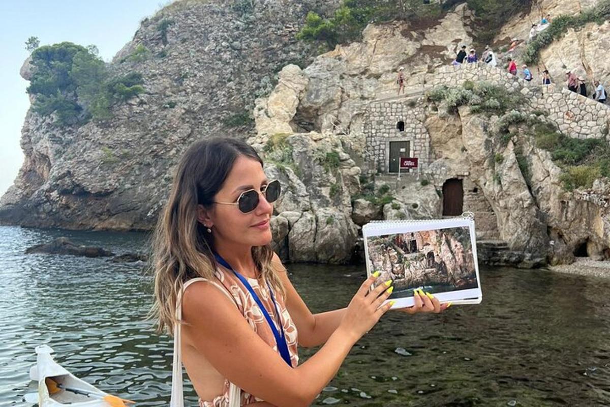 Μια γυναίκα με γυαλιά ηλίου κρατά μια φωτογραφία ενός γκρεμού