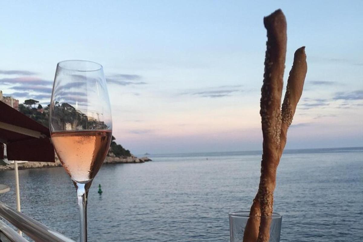 a glass of wine sitting on a table next to the water