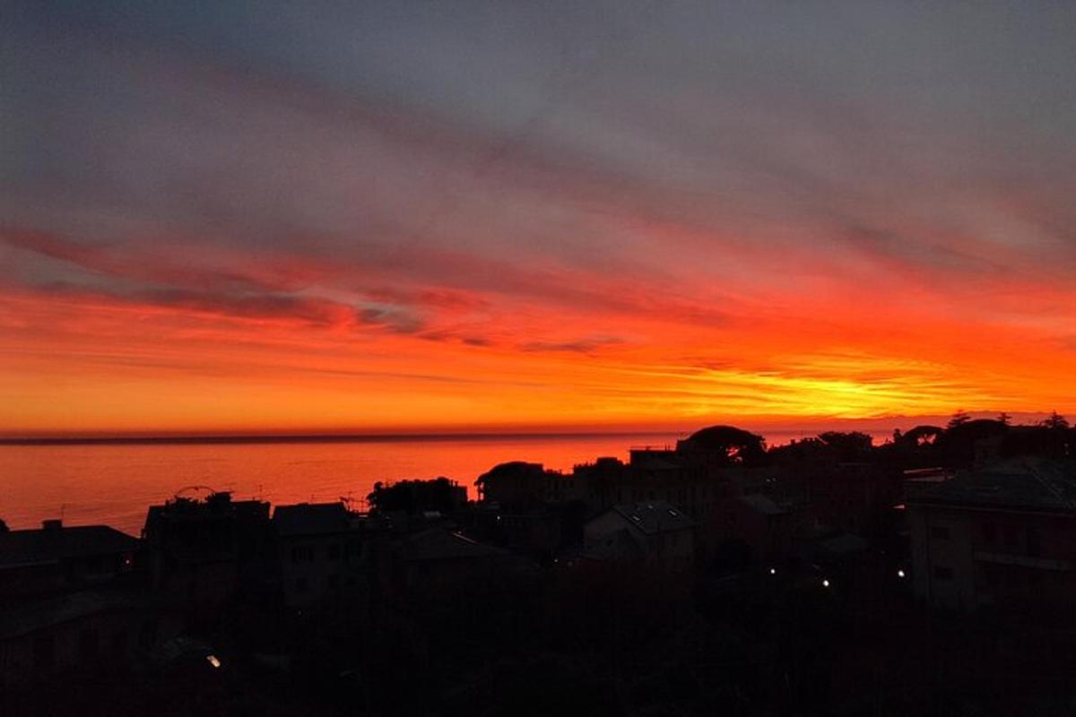 a sunset over a city with the ocean in the background