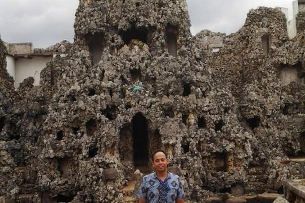 a man standing in front of a stone building