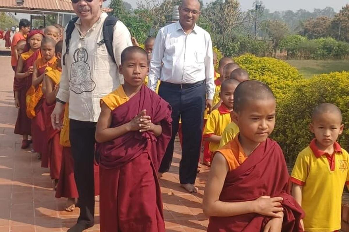 a group of children standing next to a group of people
