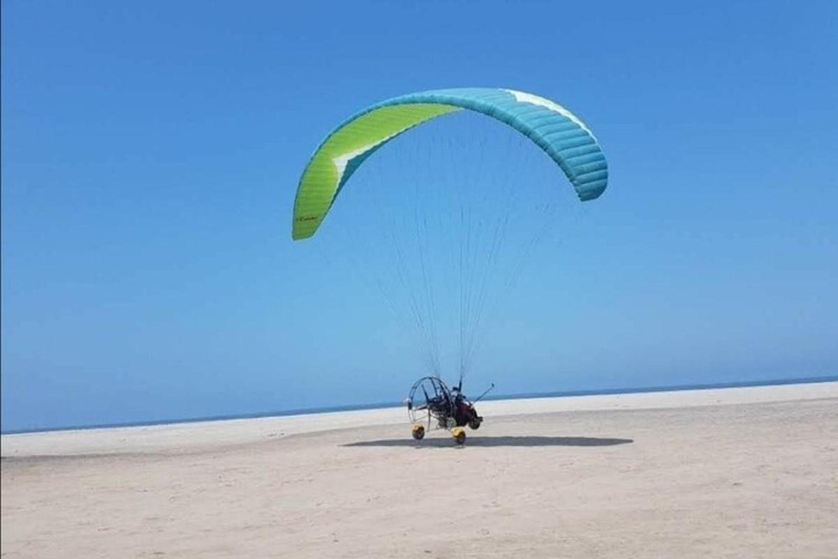 a person flying a parachute on the beach